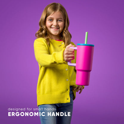Child holding hot pink 24oz insulated tumbler with turquoise lid and green straw, featuring light pink ergonomic handle. Text reads "designed for small hands" and "ERGONOMIC HANDLE."