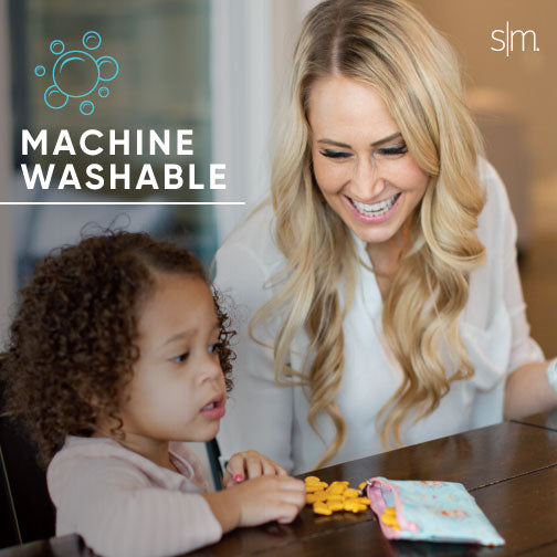 Woman with blonde hair wearing a light gray short-sleeved shirt, smiling against a warm beige and tan background